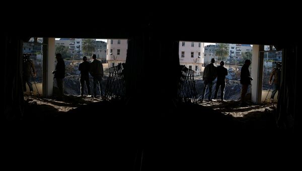 Người Palestine bên ngoài văn phòng của người đứng đầu Hamas Ismail Haniya ở thành phố Gaza, bị phá hủy bởi một cuộc không kích của Israel - Sputnik Việt Nam