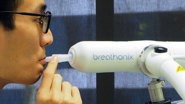 Nhân viên giới thiệu mẫu xét nghiệm phát hiện COVID-19 qua hơi thở do công ty Breathonix có trụ sở tại Singapore phát triển. - Sputnik Việt Nam
