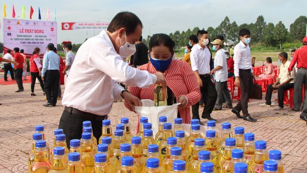 Bí thư Tỉnh ủy Hậu Giang Lê Tiến Châu trao nhu yếu phẩm cho các hộ có hoàn cảnh khó khăn tại Chợ Nhân đạo - Sputnik Việt Nam