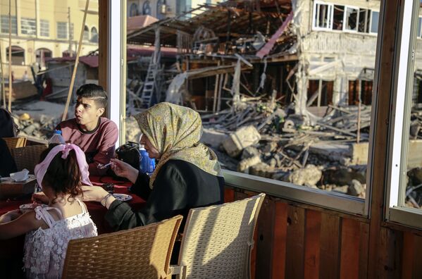 Người dân trên lãnh thổ của một ngôi nhà bị phá hủy ở Dải Gaza - Sputnik Việt Nam