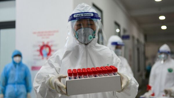Nhân viên y tế mang mẫu tăm bông để xét nghiệm Covid-19. - Sputnik Việt Nam