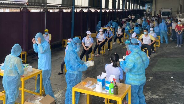 Các y bác sỹ Trung tâm kiểm soát bệnh tật Tp Hồ Chí Minh và Quận 7 thực hiện xét nghiệm sàng lọc COVID-19 ngẫu nhiên cho công nhân Công ty TNHH Solen Việt Nam ở Khu chế xuất Tân Thuận ngày 3/6. - Sputnik Việt Nam