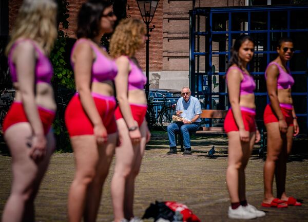 Người đàn ông nhìn các nữ sinh biểu tình ở Plaine, trung tâm thành phố cổ The Hague - Sputnik Việt Nam