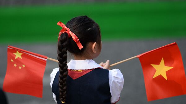 Cô gái cầm cờ Việt Nam và Trung Quốc ở Hà Nội. - Sputnik Việt Nam