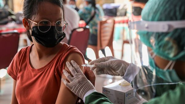 Một phụ nữ được tiêm vắc xin AstraZeneca trong chương trình tiêm chủng hàng loạt ở Sanur, Bali, Indonesia. - Sputnik Việt Nam