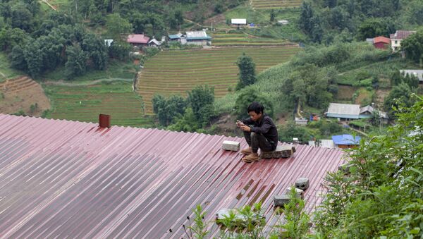 Cậu bé ngồi trên nóc tòa nhà với chiếc điện thoại thông minh, Việt Nam - Sputnik Việt Nam