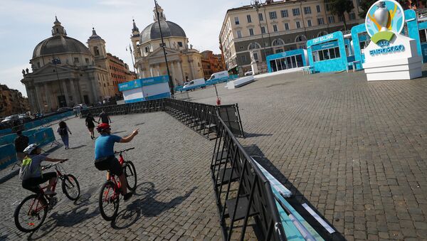 Những người đi xe đạp trong khu vực dành cho người hâm mộ ở Piazza del Popolo ở Rome, khu vực đang được trang trí chuẩn bị  cho UEFA EURO 2020. - Sputnik Việt Nam