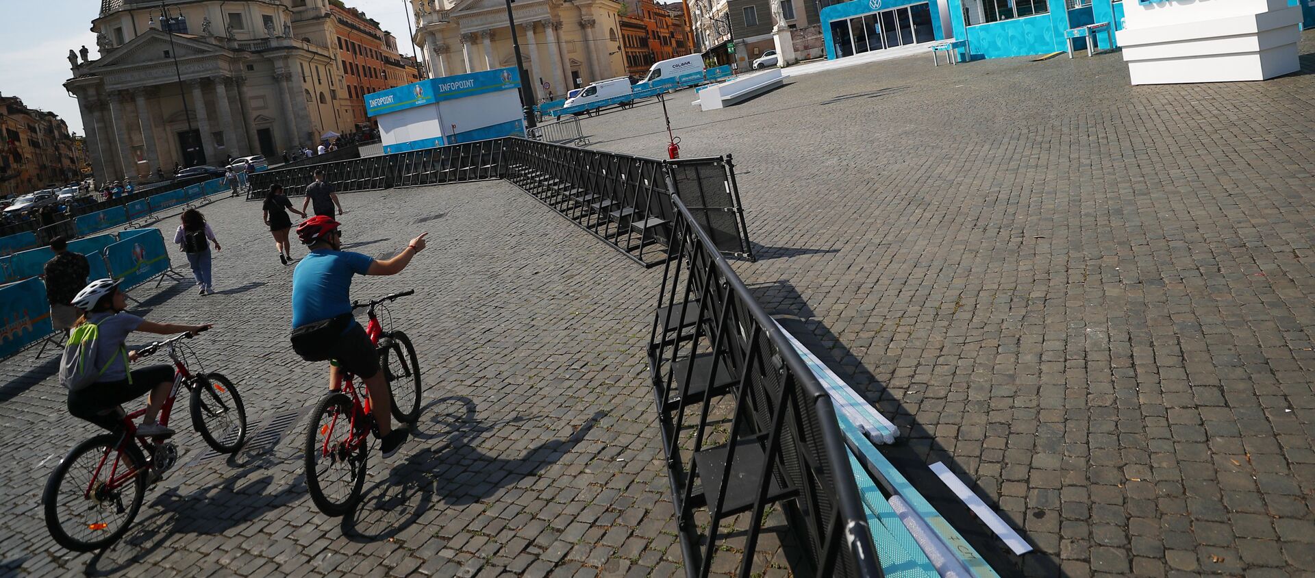 Những người đi xe đạp trong khu vực dành cho người hâm mộ ở Piazza del Popolo ở Rome, khu vực đang được trang trí chuẩn bị  cho UEFA EURO 2020. - Sputnik Việt Nam, 1920, 10.06.2021