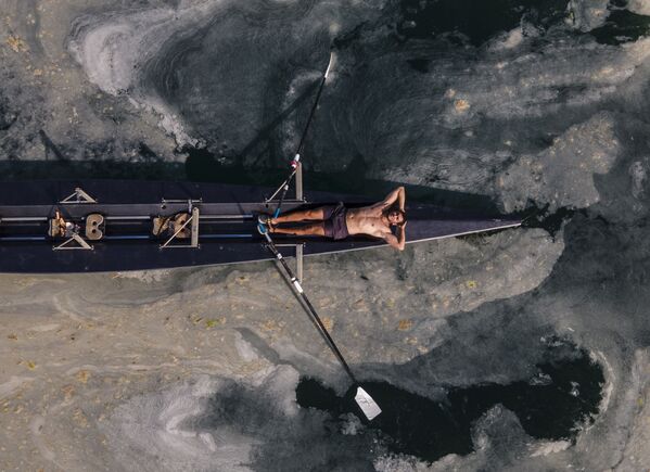 Người đàn ông đang nghỉ ngơi trên chiếc xuồng bao quanh bởi đám lớn chất nhầy biển ở biển Marmara , Thổ Nhĩ Kỳ - Sputnik Việt Nam
