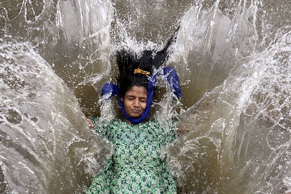 Bé gái chơi trong nước trên đường phố sau cơn mưa nhiệt đới mạnh ở Mumbai - Sputnik Việt Nam