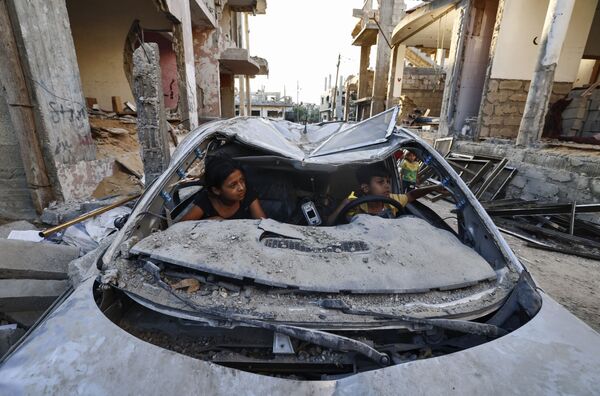Trẻ em Palestine chơi trong xe bị phá hủy trong cuộc xung đột giữa Hamas và Israel - Sputnik Việt Nam