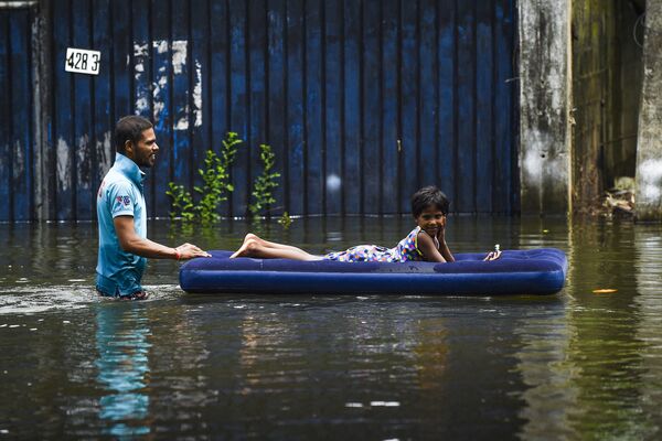 Người đàn ông và con trên tấm nệm bơm hơi trong trận lụt sau những cơn mưa nhiệt đới nghiêm trọng ở Colombo, Sri Lanka - Sputnik Việt Nam