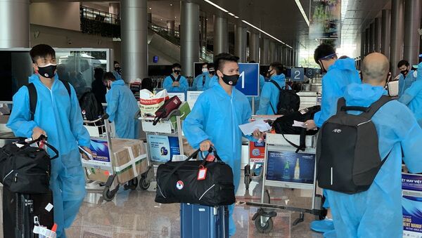 Tiền vệ Văn Đức (trái) và Quang Hải (phải) nhận hành lý tại sân bay. - Sputnik Việt Nam