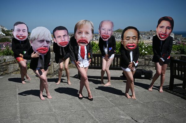 Các nhà hoạt động bảo vệ môi trường Extinction Rebellion chụp ảnh với khuôn mặt các nhà lãnh đạo G7 tại cuộc biểu tình trong thời gian diễn ra hội nghị thượng đỉnh G7 ở Anh - Sputnik Việt Nam