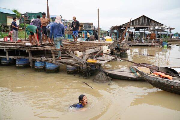 Cư dân phá dỡ nhà thuyền của mình trên sông Tonle Sap sau khi được lệnh rời khỏi thành phố trong vòng một tuần sau khi  chính quyền địa phương thông báo ở Prek Pnov, Campuchia - Sputnik Việt Nam