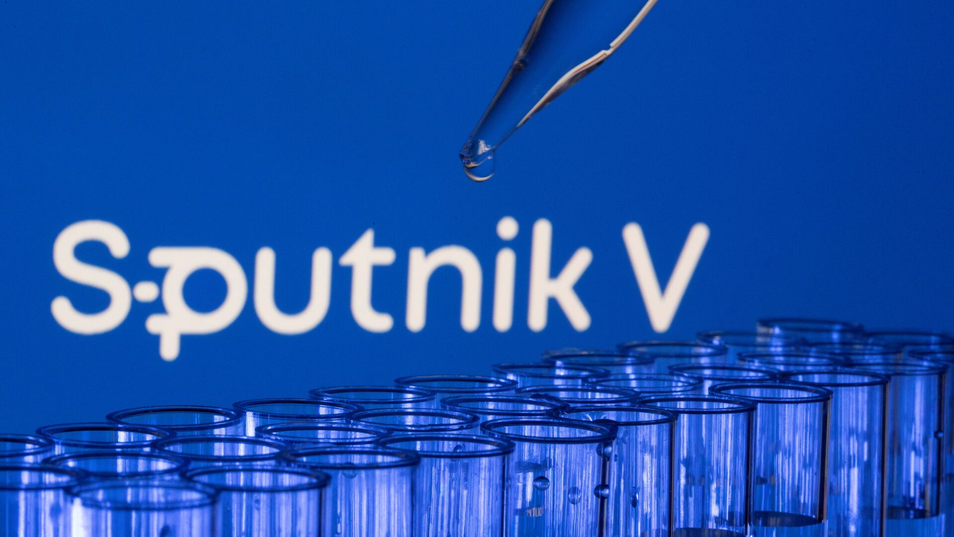 Các ống est được nhìn thấy phía trước logo Sputnik V được hiển thị trong hình minh họa này được chụp, ngày 21 tháng 5 năm 2021. - Sputnik Việt Nam, 1920, 03.12.2021