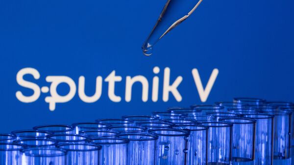 Các ống est được nhìn thấy phía trước logo Sputnik V được hiển thị trong hình minh họa này được chụp, ngày 21 tháng 5 năm 2021. - Sputnik Việt Nam