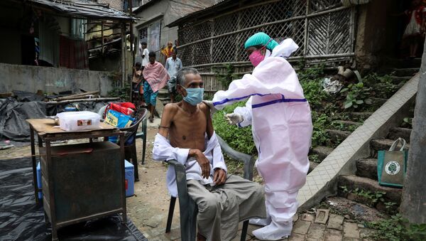 Motiar Rahman, một người dân trong làng, nhận một liều vắc-xin COVISHIELD, vắc-xin phòng bệnh do coronavirus (COVID-19) do Viện Huyết thanh của Ấn Độ sản xuất, trong một đợt tiêm chủng và thử nghiệm tận nhà tại Đảo Uttar Batora ở quận Howrah ở Tây Bengal bang, Ấn Độ, ngày 21 tháng 6 năm 2021. - Sputnik Việt Nam