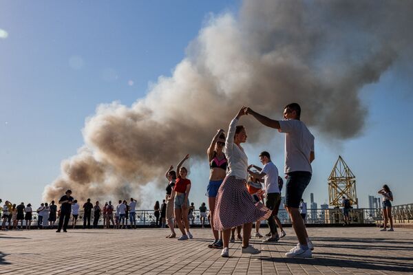 Cặp đôi nhảy vũ điệu samba trong nền khói bốc lên từ đám cháy kho pháo hoa ở Matxcơva  - Sputnik Việt Nam