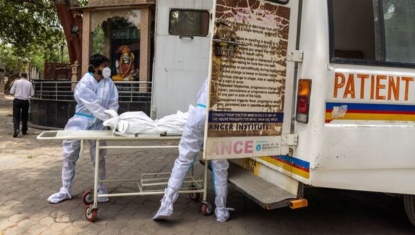 Các bác sĩ đưa xác một người chết vì coronavirus vào ô tô. - Sputnik Việt Nam