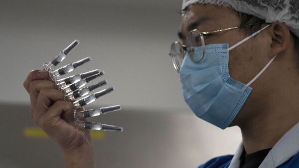 Một nhân viên kiểm tra ống tiêm có vắc xin SARS-CoV-2 tại một nhà máy ở Bắc Kinh. - Sputnik Việt Nam