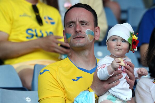 Cổ động viên Ukraina với đứa trẻ ăn bánh quy chờ trận đấu bắt đầu - Sputnik Việt Nam