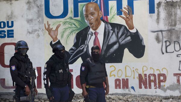 Cảnh sát đứng gần bức tranh tường có hình Tổng thống Haiti Jovenel Moise, gần tư dinh của nhà lãnh đạo nơi ông bị giết bởi các tay súng vào sáng sớm ở Port-au-Prince, Haiti, Thứ Tư, ngày 7 tháng 7 năm 2021. - Sputnik Việt Nam