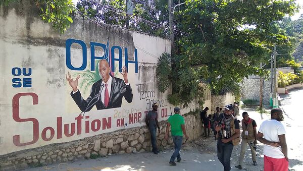 Mọi người đi ngang qua bức tường vẽ hình Tổng thống Haiti Jovenel Moise, sau khi ông bị những kẻ tấn công chưa rõ danh tính bắn chết tại dinh thự ở thủ đô Port-au-Prince, Haiti vào ngày 7/7/2021 - Sputnik Việt Nam