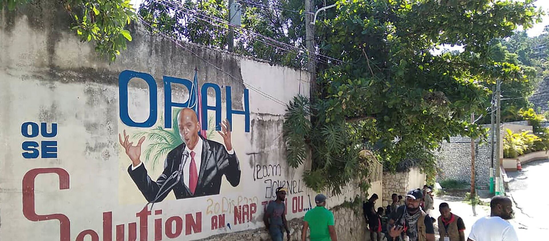 Mọi người đi ngang qua bức tường vẽ hình Tổng thống Haiti Jovenel Moise, sau khi ông bị những kẻ tấn công chưa rõ danh tính bắn chết tại dinh thự ở thủ đô Port-au-Prince, Haiti vào ngày 7/7/2021 - Sputnik Việt Nam, 1920, 09.07.2021