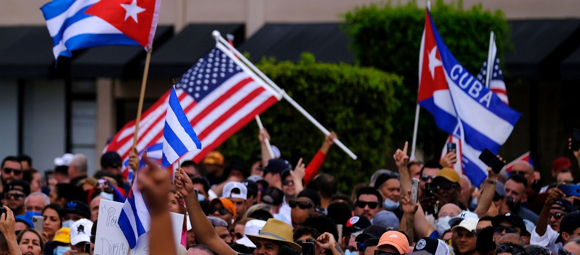 Emigres in Little Havana wave American and Cuban flags as they react to reports of protests in Cuba against the deteriorating economy, in Miami, Florida, U.S., July 11, 2021 - Sputnik Việt Nam, 1920, 21.07.2021