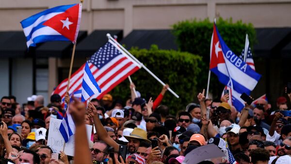 Emigres in Little Havana wave American and Cuban flags as they react to reports of protests in Cuba against the deteriorating economy, in Miami, Florida, U.S., July 11, 2021 - Sputnik Việt Nam