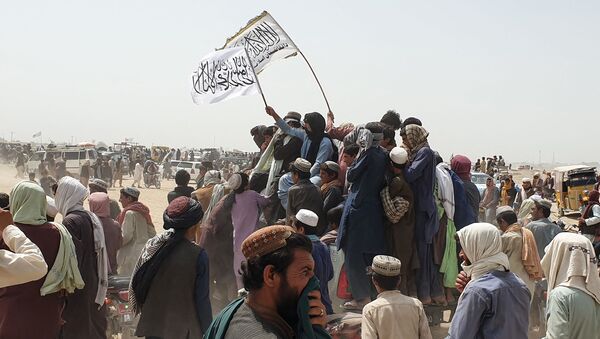 Mọi người vẫy cờ Taliban khi họ lái xe qua thị trấn biên giới Chaman của Pakistan vào ngày 14 tháng 7 năm 2021, sau khi Taliban tuyên bố rằng họ đã chiếm được phía Afghanistan của ngã ba biên giới Spin Boldak dọc theo biên giới với Pakistan - Sputnik Việt Nam