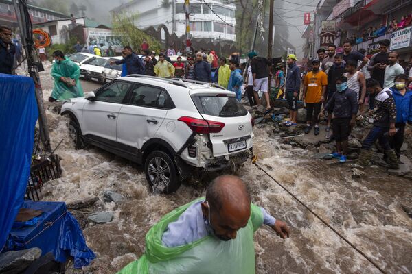 Mọi người cố gắng kéo chiếc ô tô bị hư hỏng trong trận lũ lụt ở Ấn Độ - Sputnik Việt Nam