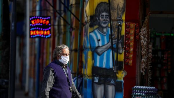Người đàn ông đi qua bức vẽ graffiti mô tả Diego Maradona - Sputnik Việt Nam