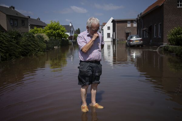 Người đàn ông trên con phố ngập nước bên ngoài ngôi nhà của mình ở Hà Lan - Sputnik Việt Nam