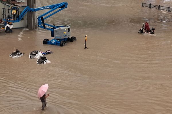 Người dân lội trên đường phố ngập nước sau đợt mưa lớn ở Trịnh Châu thuộc tỉnh Hà Nam, miền Trung Trung Quốc - Sputnik Việt Nam