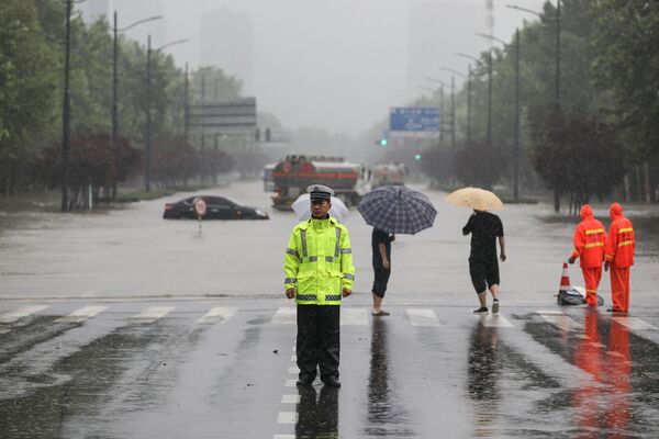 Sĩ quan cảnh sát băng qua con phố ngập nước  sau  lũ lụt ở Trịnh Châu thuộc tỉnh Hà Nam, miền Trung Trung Quốc - Sputnik Việt Nam