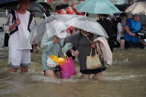 Mọi người đi trên con phố ngập lụt ở Trịnh Châu, tỉnh Hà Nam, Trung Quốc - Sputnik Việt Nam