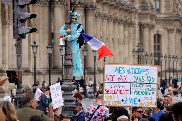 Một người biểu tình hóa trang thành Tượng Nữ thần Tự do tham gia cuộc biểu tình phản đối các biện pháp mới mà Tổng thống Pháp Emmanuel Macron công bố nhằm chống lại sự bùng phát COVID ở Paris, Pháp - Sputnik Việt Nam