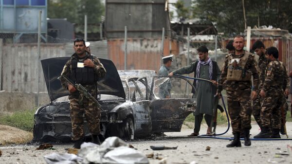 Nhân viên an ninh kiểm tra một chiếc xe bị hư hại trong cuộc pháo kích vào Kabul - Sputnik Việt Nam
