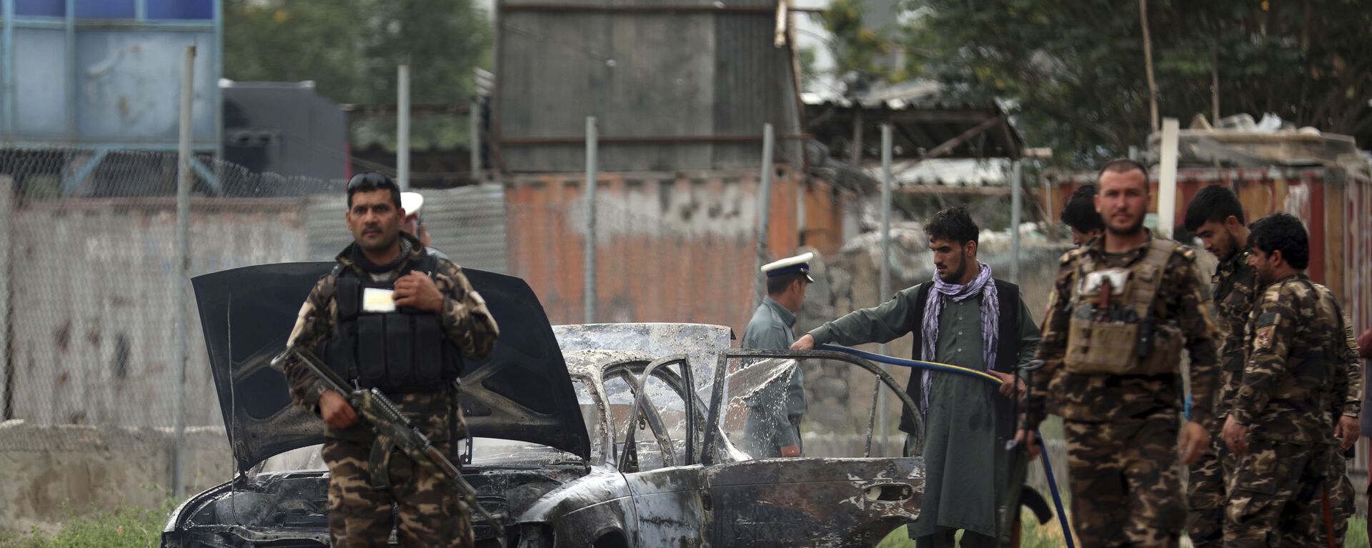 Nhân viên an ninh kiểm tra một chiếc xe bị hư hại trong cuộc pháo kích vào Kabul - Sputnik Việt Nam, 1920, 26.07.2021