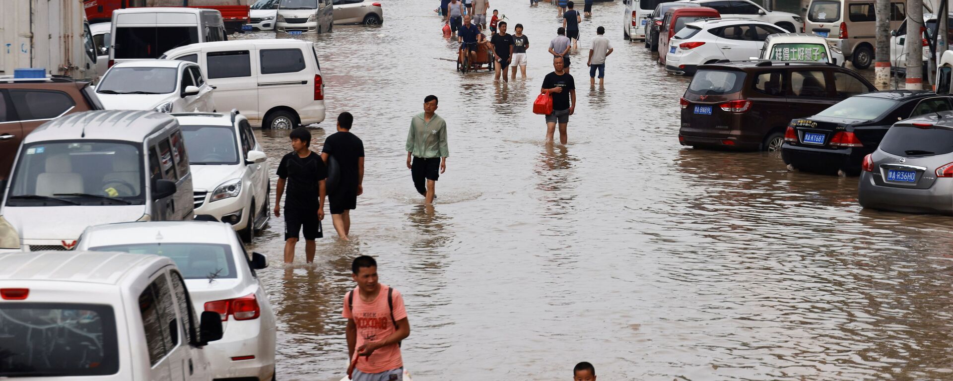 Người dân băng qua dòng nước lũ sau trận mưa lớn ở Trịnh Châu, tỉnh Hà Nam, Trung Quốc - Sputnik Việt Nam, 1920, 28.07.2021
