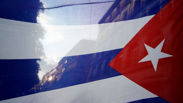 Hình bóng của thành phố được nhìn thấy qua lá cờ Cuba trong cuộc biểu tình phản đối lệnh cấm vận kinh tế của Hoa Kỳ ở Cuba - Sputnik Việt Nam