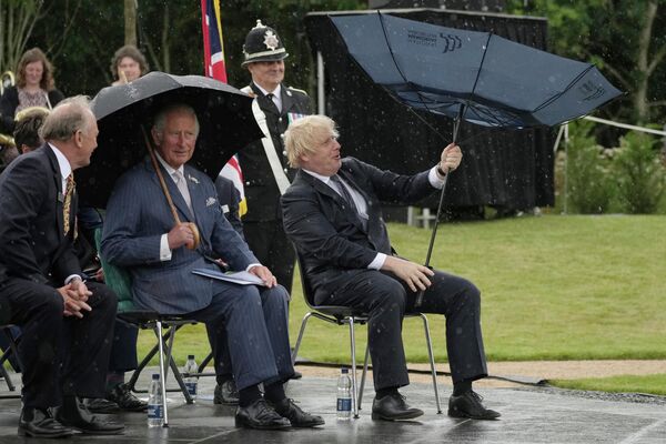 Thái tử Anh Charles và Thủ tướng Boris Johnson trú mưa trong lễ khai trương Đài tưởng niệm Cảnh sát Anh ở Olrewas, Anh - Sputnik Việt Nam