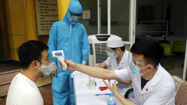 Đo thân nhiệt cho người dân đến khám, chữa bệnh tại Bệnh viện Dệt may - Sputnik Việt Nam
