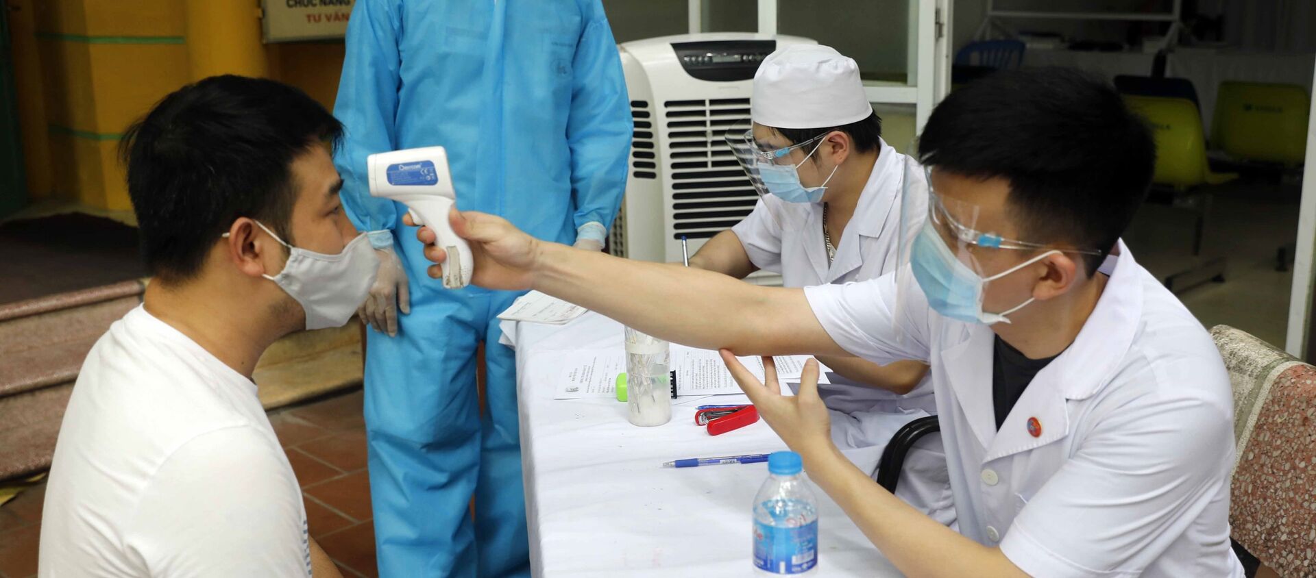 Đo thân nhiệt cho người dân đến khám, chữa bệnh tại Bệnh viện Dệt may - Sputnik Việt Nam, 1920, 31.07.2021