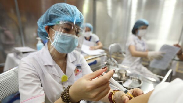 Nhân viên y tế tiêm vaccine phòng COVID-19 cho người dân, ngày 02/8/2021 - Sputnik Việt Nam