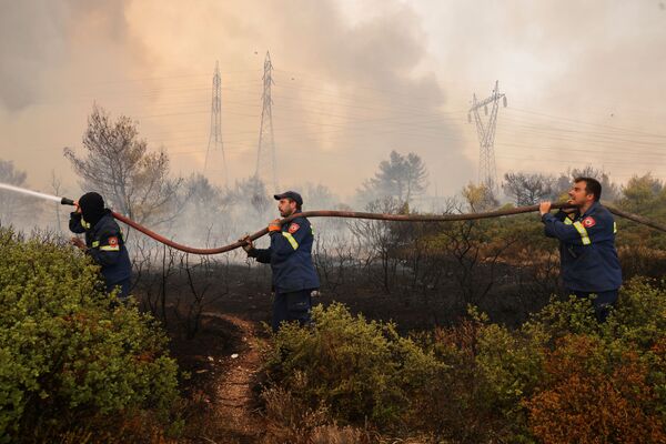 Người tình nguyện cứu hỏa cố gắng dập lửa ở Varympompi, phía bắc ngoại ô Athens, Hy Lạp - Sputnik Việt Nam