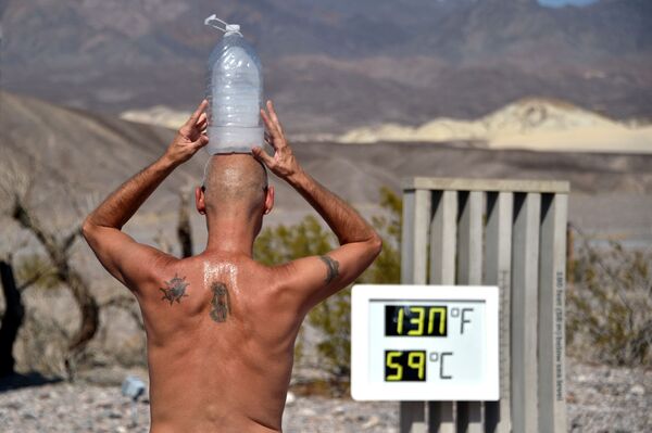 Người đàn ông với chai nước đá trên đầu khi nhiệt độ cao ở Thung lũng Chết (Death Valley), California - Sputnik Việt Nam