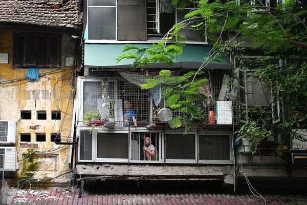 Trẻ em ở trong nhà nhìn ra phố vắng trong đợt cách ly xã hội ở Hà Nội, Việt Nam. - Sputnik Việt Nam